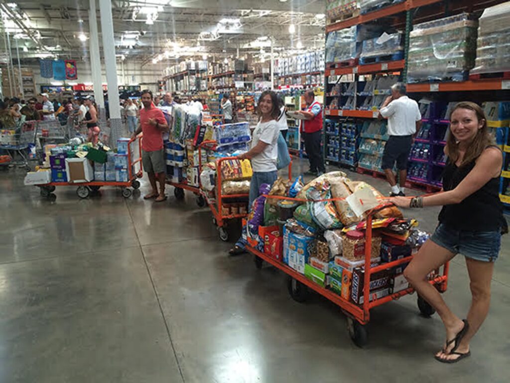 People loading carts with groceries in a warehouse store.