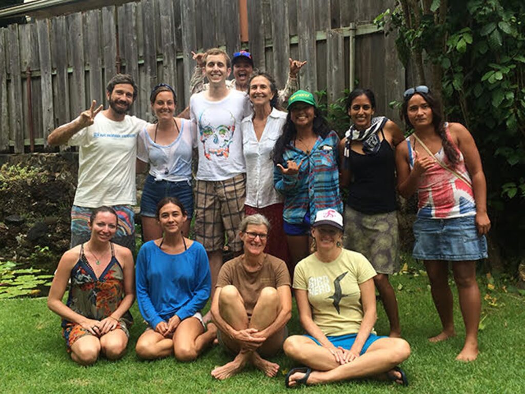 A group of people posing happily outdoors in casual summer clothes.